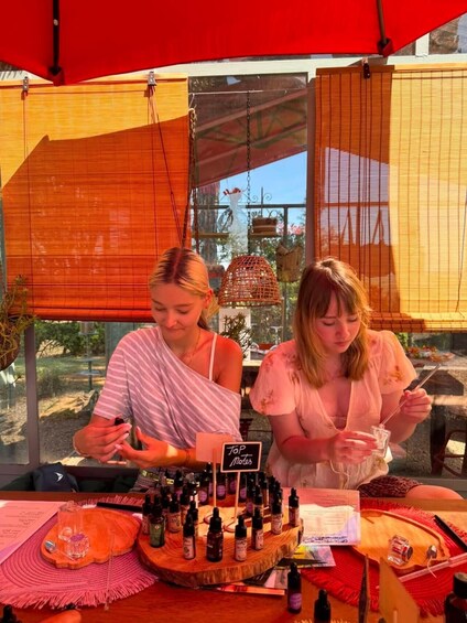 Two people at a booth with various bottles and a sign that reads 'Top Notes'. 1