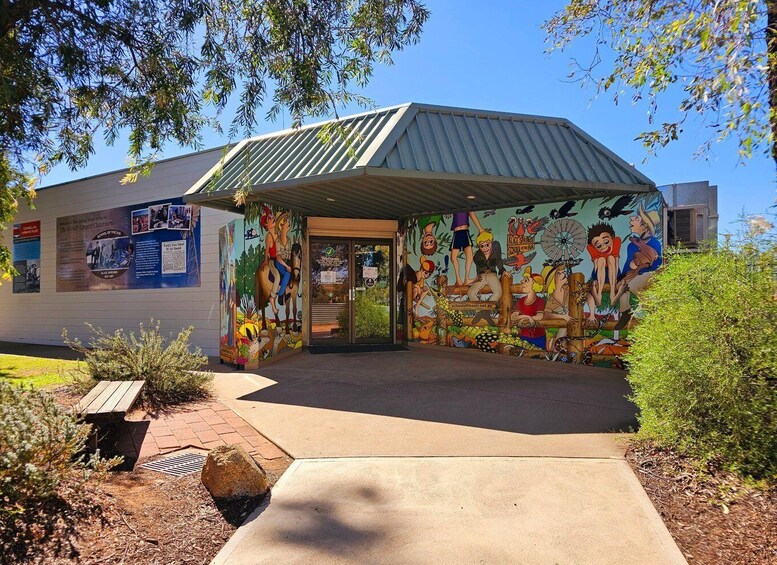A building with a mural of cartoon characters on the side. 1