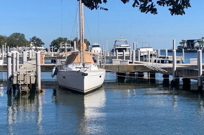 Een zeilboot afgemeerd in een jachthaven, met andere boten en een heldere lucht. 2