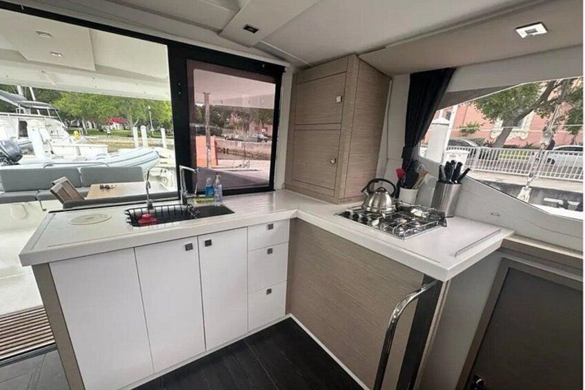 A compact kitchen with white cabinets, a sink, and a stove. 4