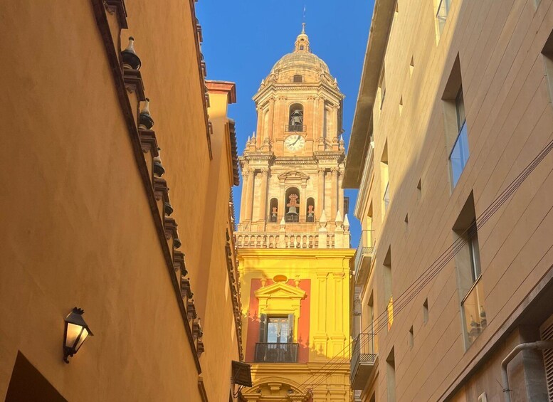 A street view with a prominent church tower and adjacent buildings. 4
