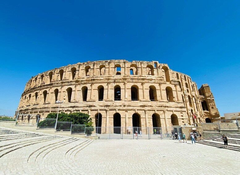 The Colosseum in Rome, Italy, with tourists walking around. 1