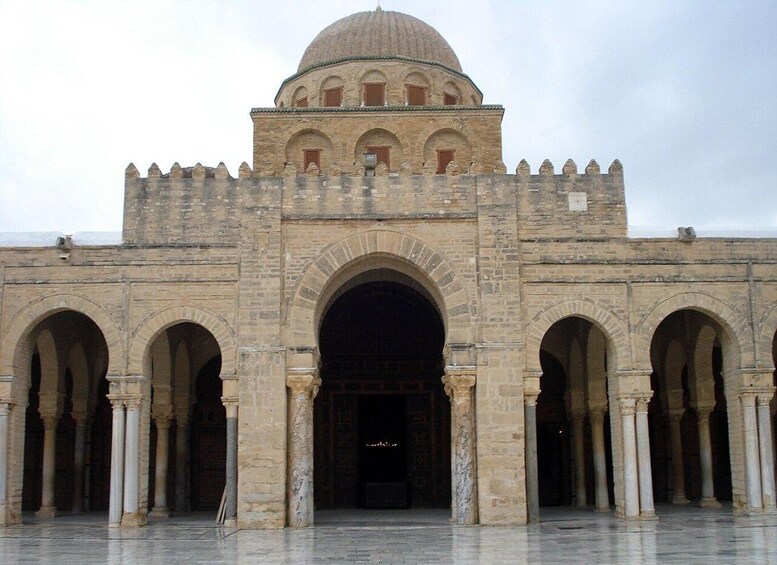 A large stone building with a central dome and multiple arches. 5
