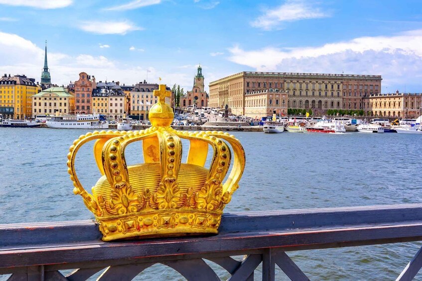A golden crown on a bridge with a cityscape in the background. 2