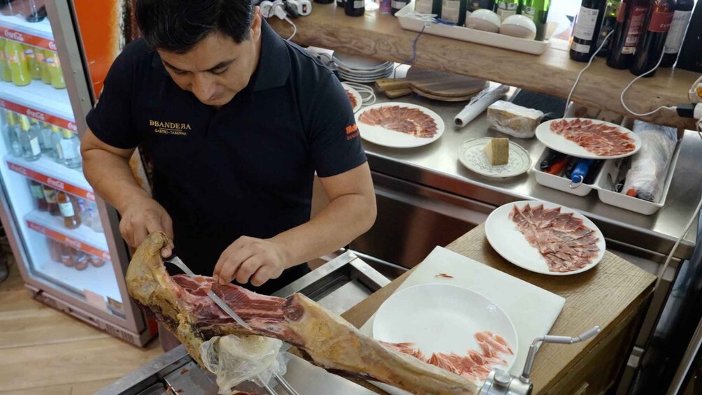 A person slicing meat on a butcher's block. 1