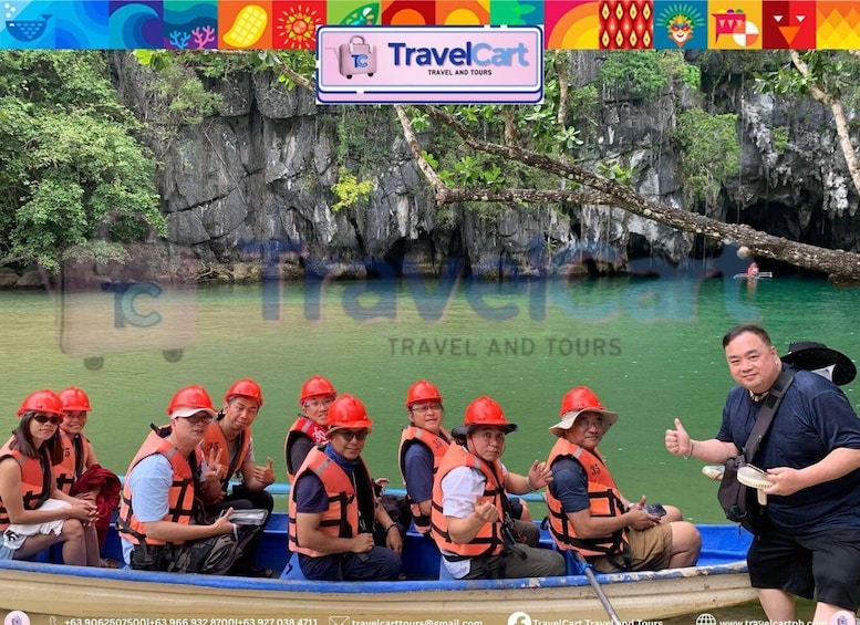 A group of people in a boat wearing life jackets and helmets, with a rocky riverbank and greenery in the background. 1