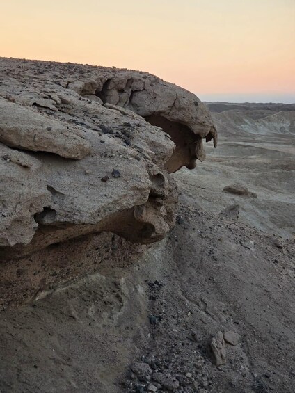A rocky landscape with a large rock formation and a small cave entrance. 3