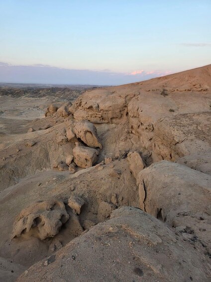 A rocky desert landscape with large boulders and a distant view of the horizon. 4