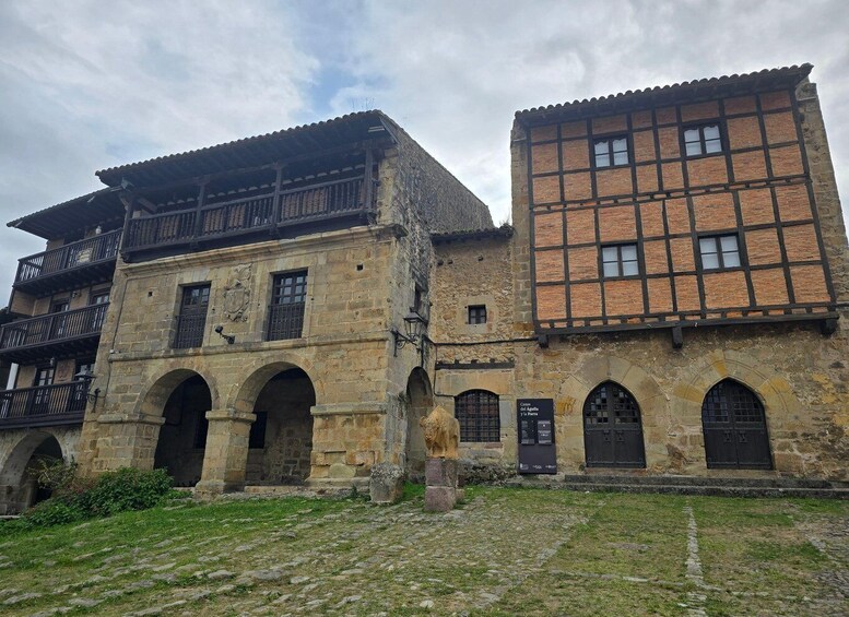 A historic building with stone arches and a wooden balcony. 5