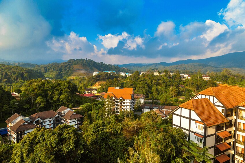 A mountainous landscape with residential buildings and lush greenery. 3