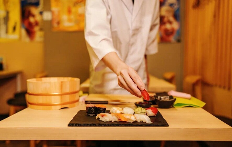 A sushi chef preparing sushi at a counter. 2