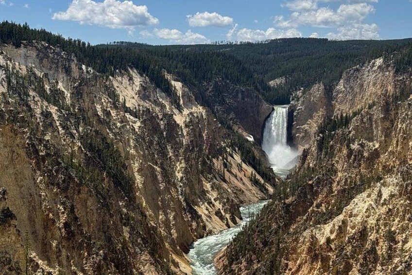 A canyon with a waterfall, steep cliffs, and a river. 1