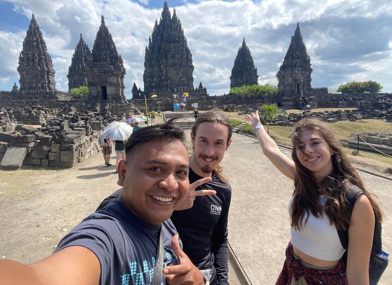 A group of people taking a selfie in front of ancient temple ruins. 4