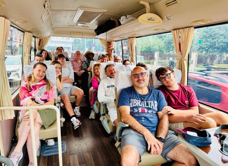 A bus interior with passengers seated, windows with curtains, and a view of the outside. 4