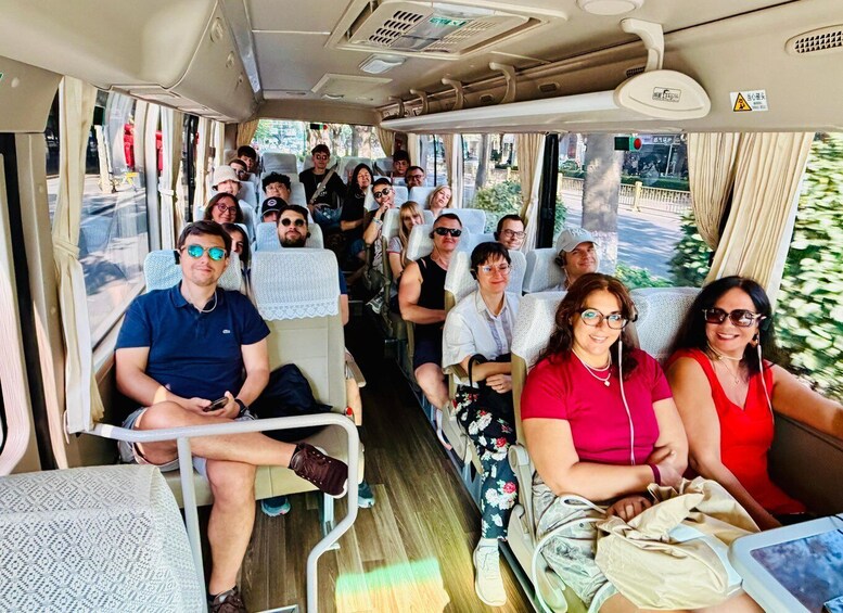 A bus interior with passengers seated and a view of the outside. 5