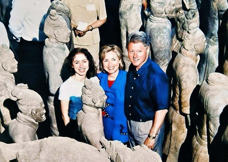 A group of people standing among stone sculptures. 2