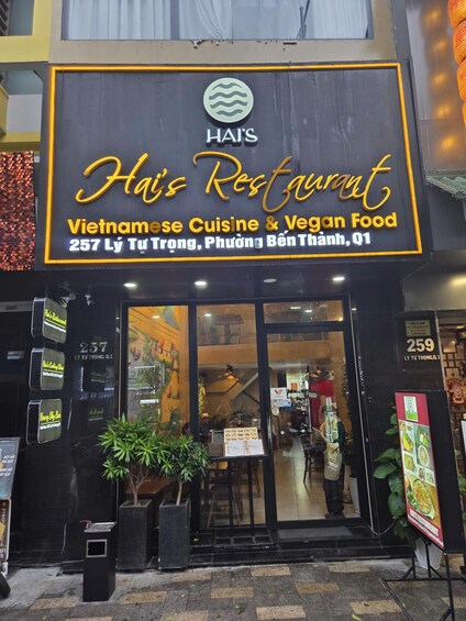 A storefront with a sign for 'Haj's Restaurant' offering Vietnamese cuisine and vegan food. 2