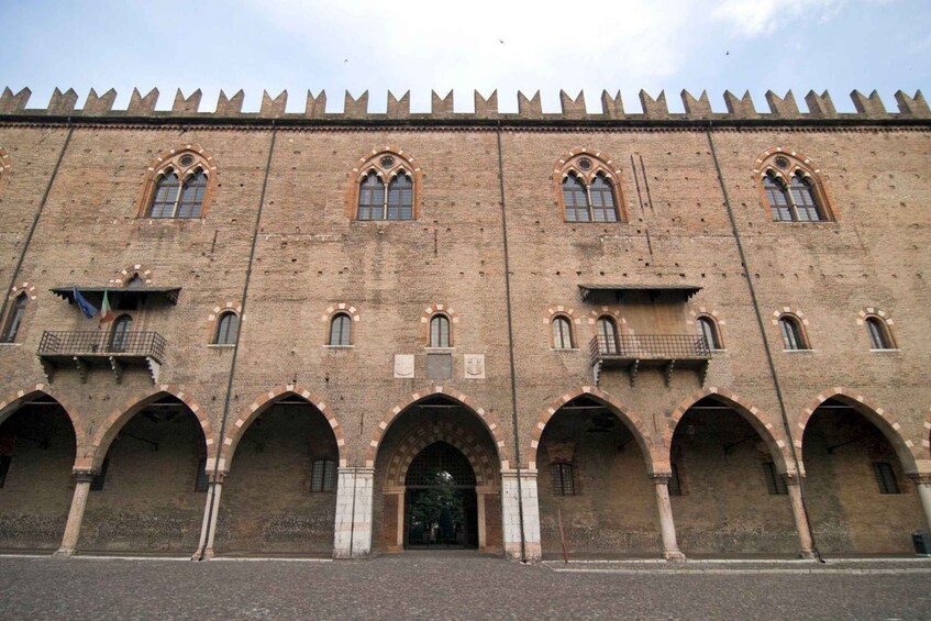 A historic building with arched windows and a crenellated top. 3
