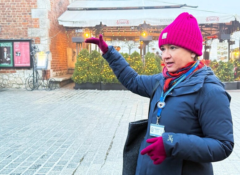 A person pointing towards a building with a sign that reads "RATUSZOWA". 2