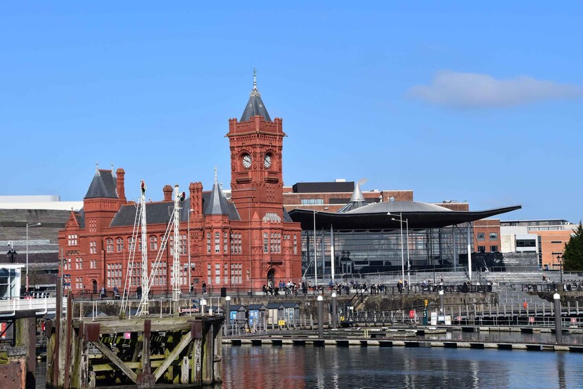 A red building with a clock tower and a modern glass structure. 2