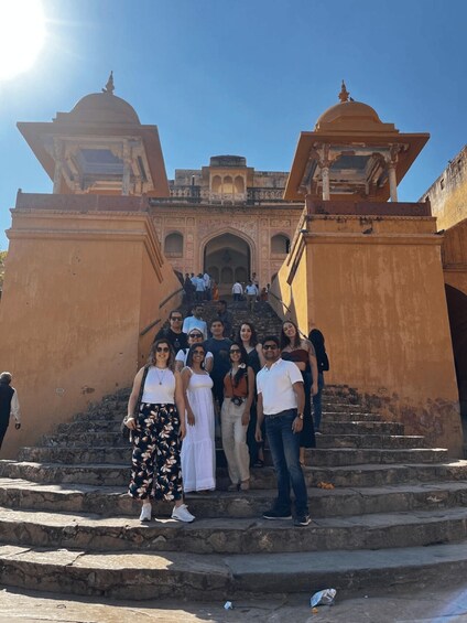 A group of people standing on stone steps in front of a historical building with domed structures. 5