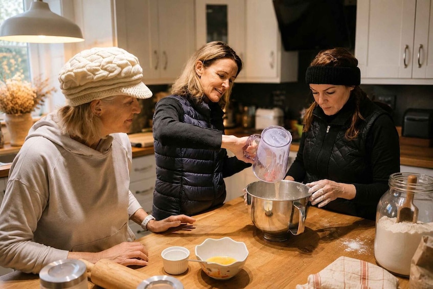 Three people in a kitchen preparing food, with ingredients and kitchen utensils on the table. 3