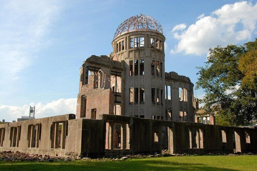 Un ampio edificio circolare con una cupola e numerose finestre, circondato da un'area erbosa e alberi. 5