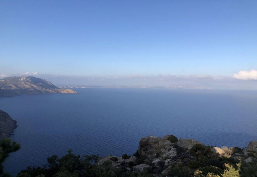 A coastal landscape with a clear view of the sea and distant mountains. 2