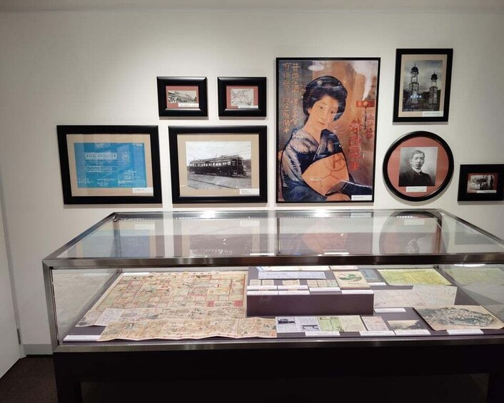 A museum display with framed pictures and a glass case containing historical documents. 1