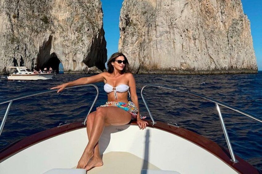 A person on a boat with rocky cliffs in the background. 1