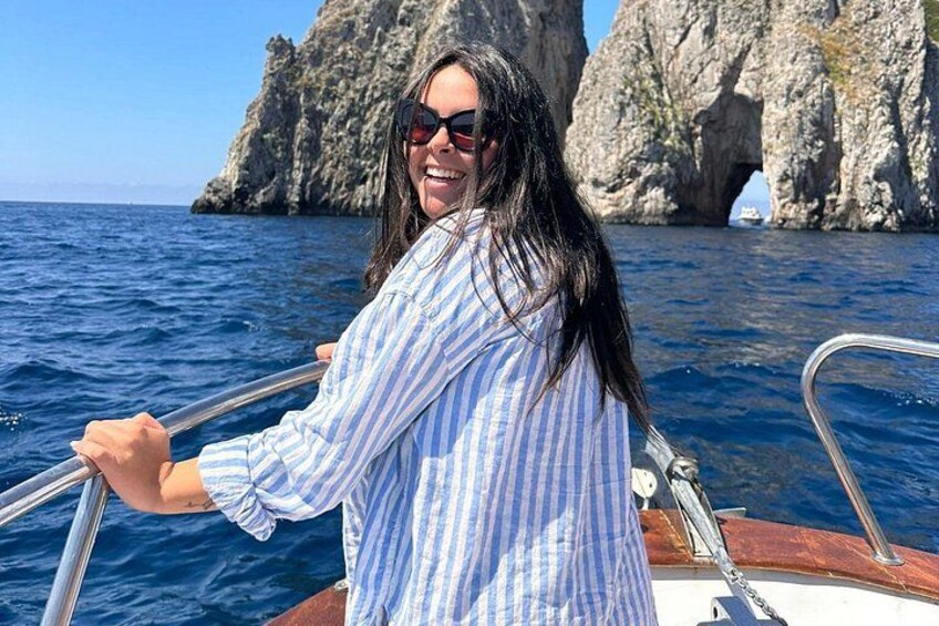 A person on a boat with a rocky coastline in the background. 4