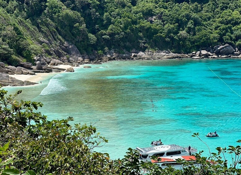 A turquoise coastal area with clear waters, rocky shores, and dense greenery. 4