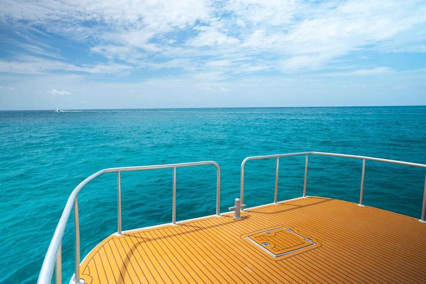 A wooden deck with metal railings overlooking turquoise ocean water. 5