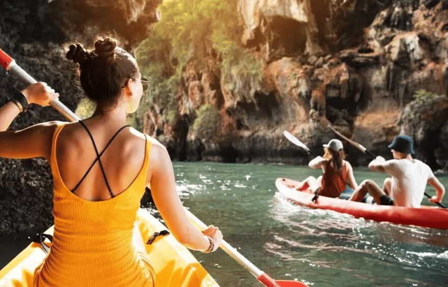 A group kayaking on a river surrounded by rocky cliffs. 1