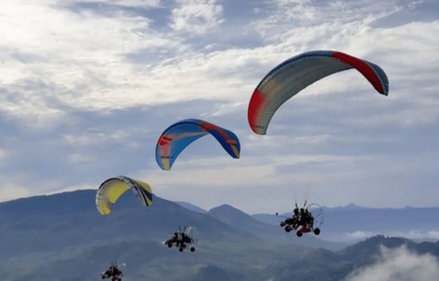 Paragliders flying over a mountainous landscape. 2