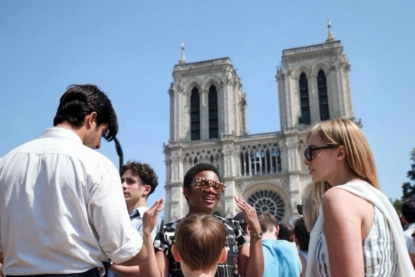 A crowd of people in front of a large cathedral with two towers. 1