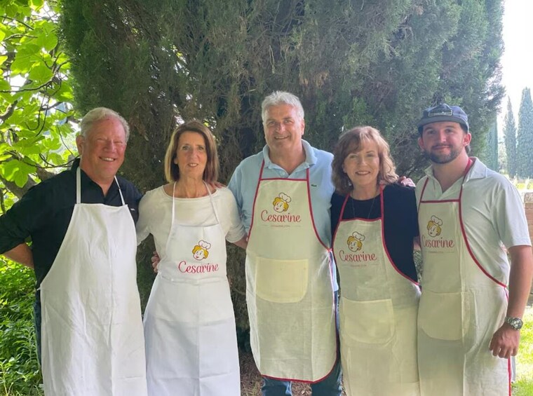 Cinco personas con delantales que llevan el nombre 'Cesarine' y un logotipo de chef. 1