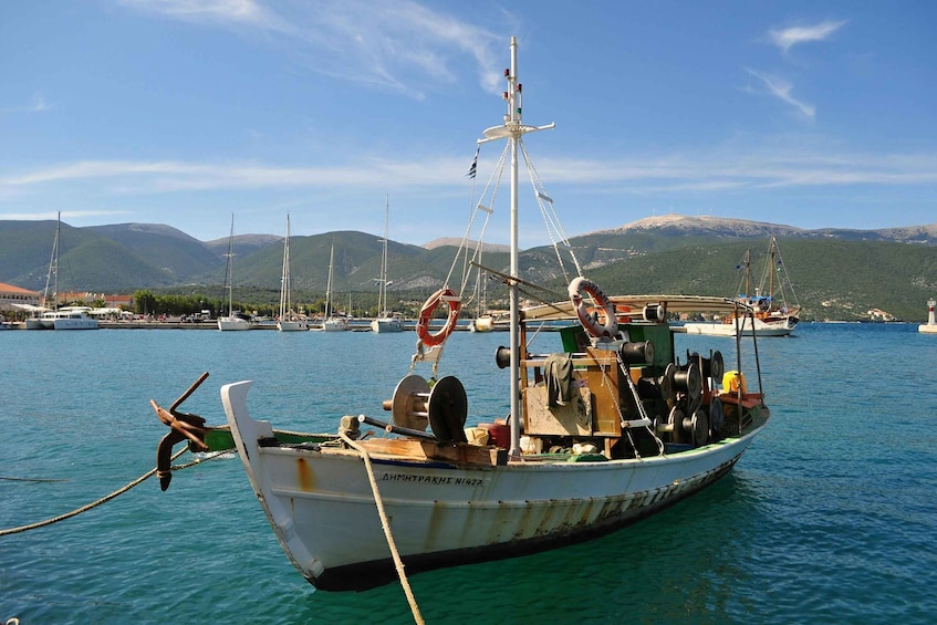 A fishing boat docked at a harbor with mountains in the background. 5