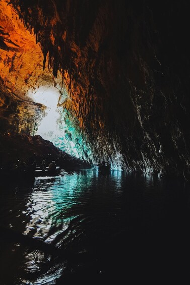 A cave with illuminated walls and water reflecting light. 3