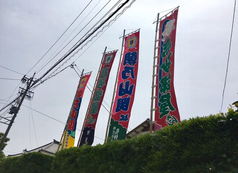 A row of vertical banners with text and logos, attached to a pole. 3