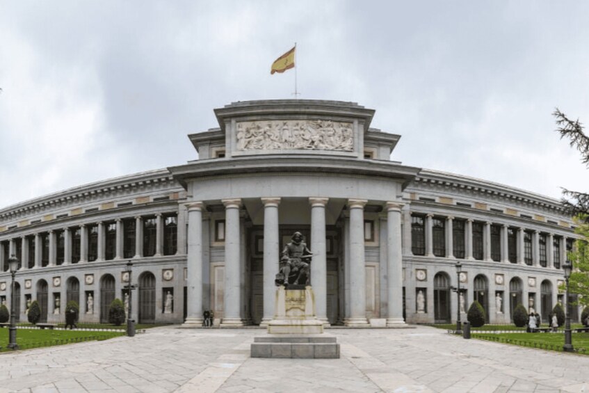 A grand neoclassical building with a central statue, columns, and a flag. 5
