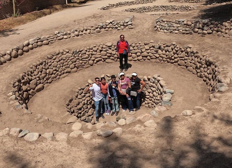 A group of people standing in a circular stone formation. 1