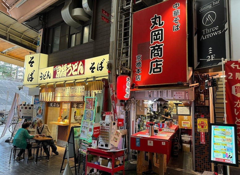 A street food market with various food stalls and a PayPay payment machine. 3