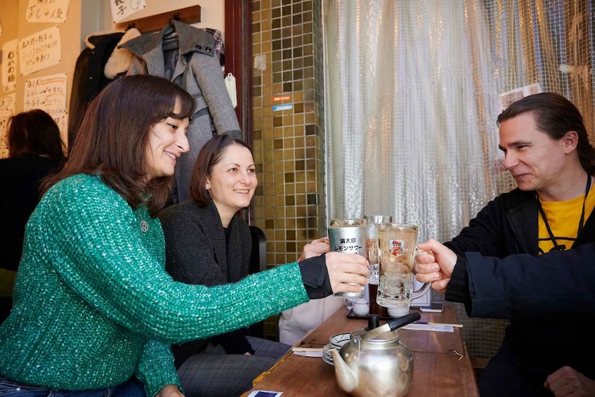 Three people toasting with drinks at a table in a restaurant. 5