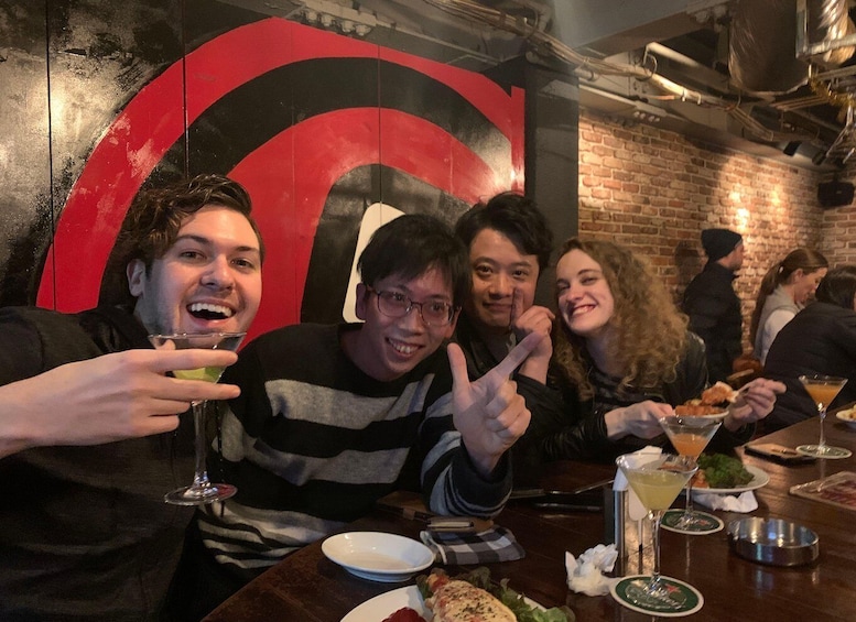 A group of people dining at a restaurant with a large red logo on the wall. 4