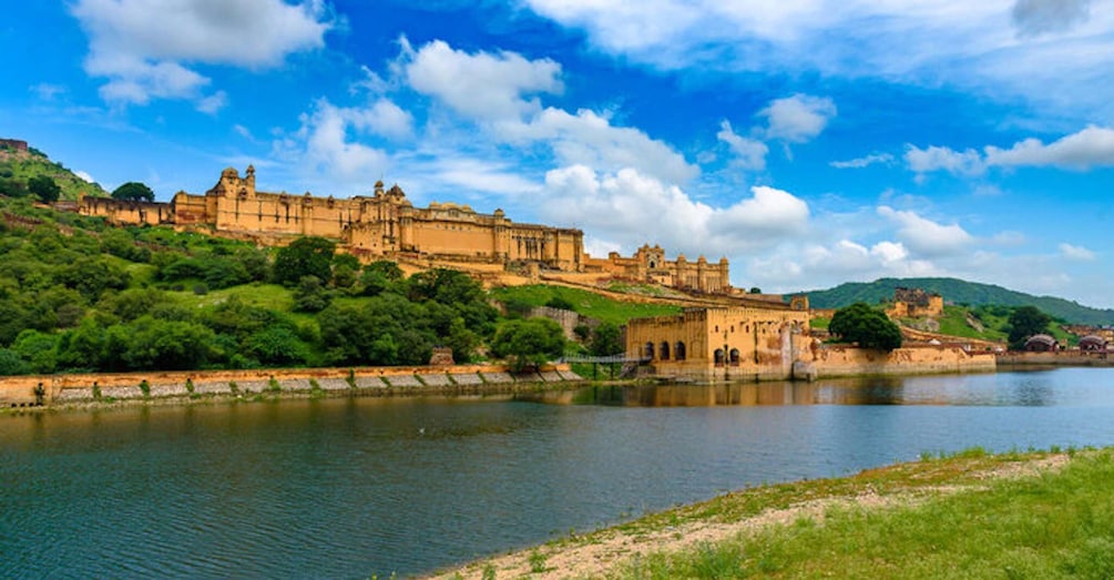 A historic fort overlooking a river, surrounded by lush greenery and hills. 4