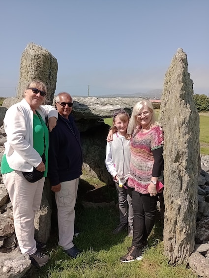 A family standing in front of stone structures with a clear sky in the background. 2
