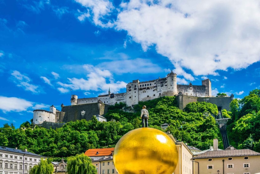 A castle on a hill with a golden sphere in the foreground. 4