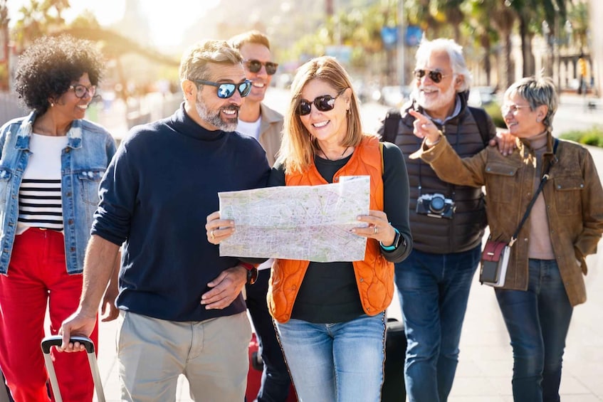 A group of people walking outdoors, some holding a map. 5