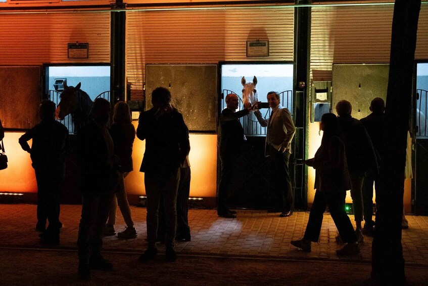 A group of people standing outside a building with metal gates. 4